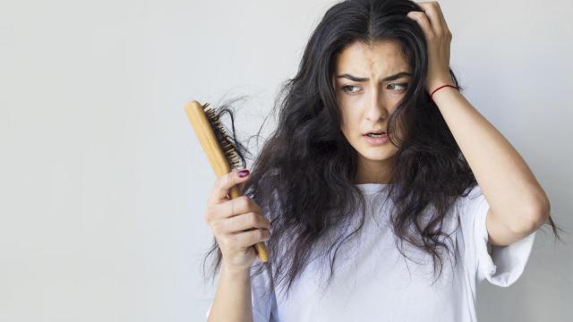 Imagen de archivo mujer con caída de pelo al cepillarse