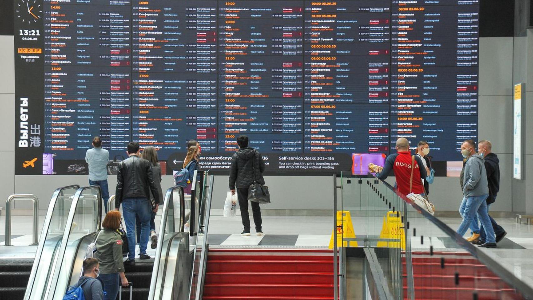 Pasajeros delante de una pantalla de vuelos en el aeropuerto de Moscú.