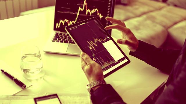 Un inversor consulta la bolsa en una tableta y su ordenador portátil.