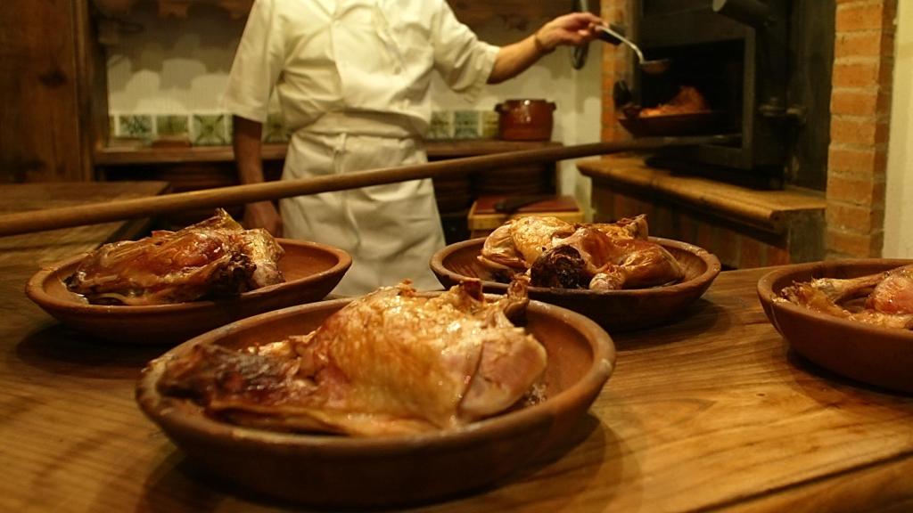 Imagen de archivo de varios lechazos y un maestro asador.