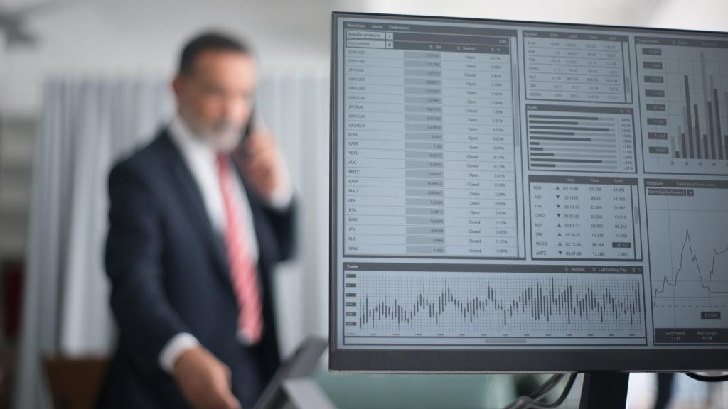 Un gestor de inversiones opera junto a la pantalla de cotizaciones.