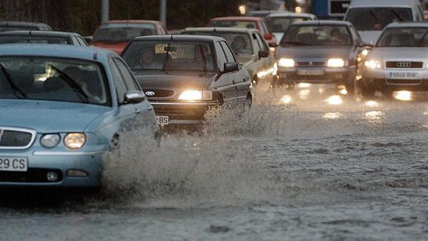 Vehículos circulando con lluvia.
