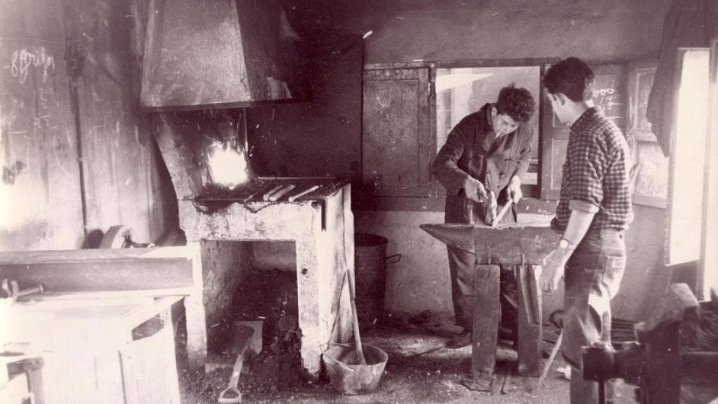Una típica fragua con yunque y carbón, y el pitillo entre los labios del herrero