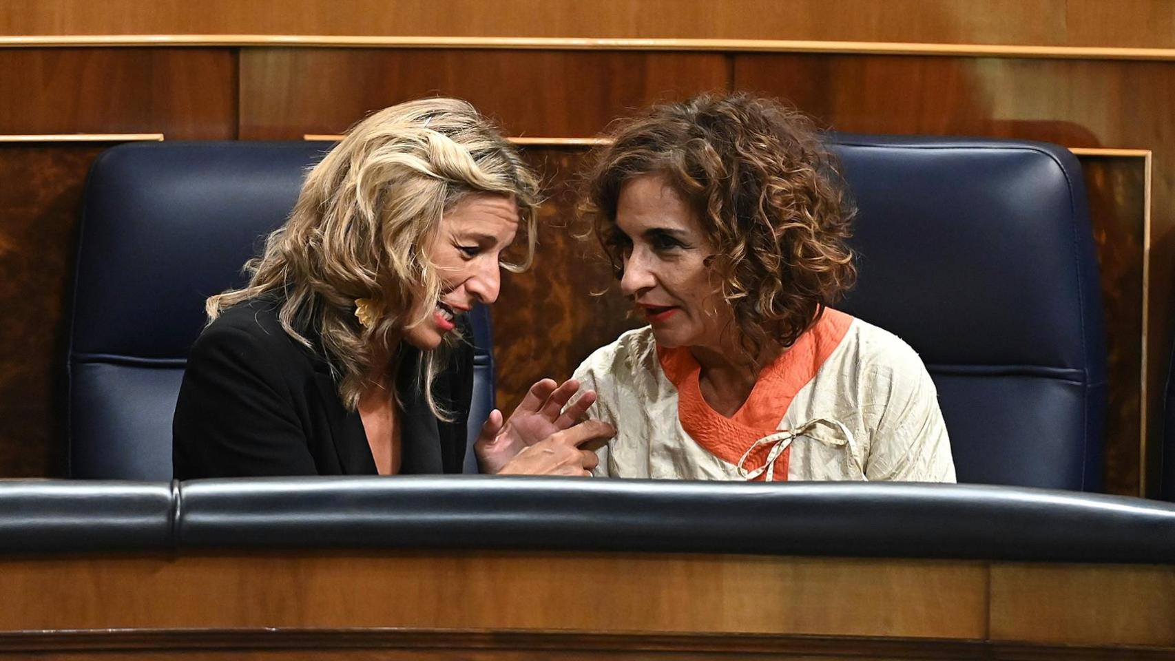 La vicepresidenta segunda y ministra de Trabajo y Economía Social, Yolanda Díaz, conversa con la ministra de Hacienda, María Jesús Montero, durante el pleno del Congreso.