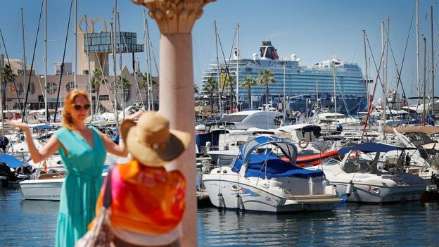 Dos turistas posan frente al puerto deportivo de Alicante, uno de los destinos elegidos.