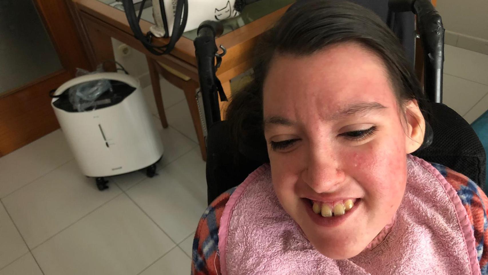 Raquel en su casa con el oxígeno de emergencia al fondo.