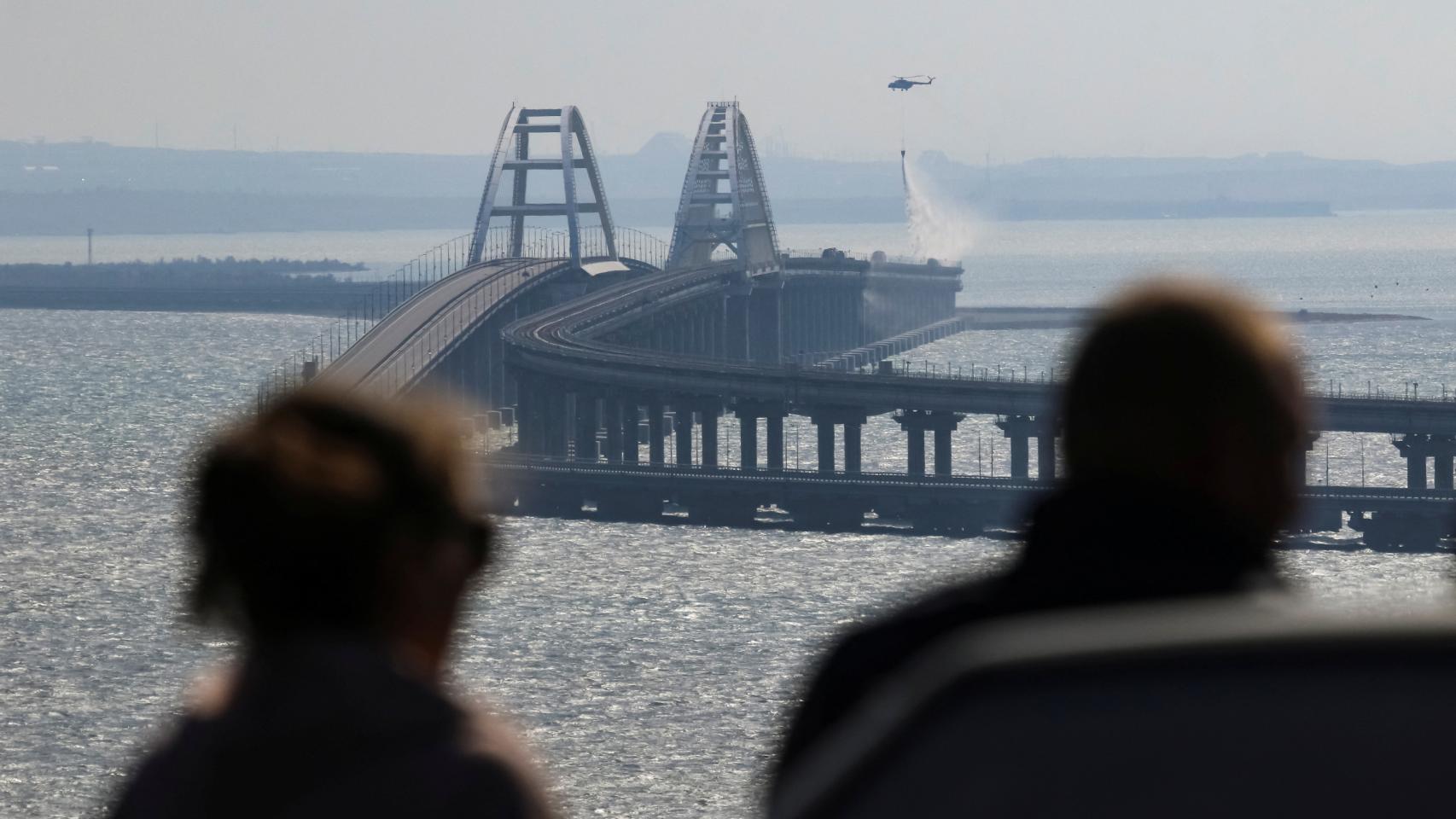 Un helicóptero sofoca las llamas del incendio provocado en el puente de Kerch tras la explosión de un camión.