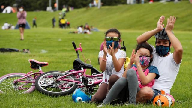 Un padre y sus dos hijas disfrutan de un día en el parque.