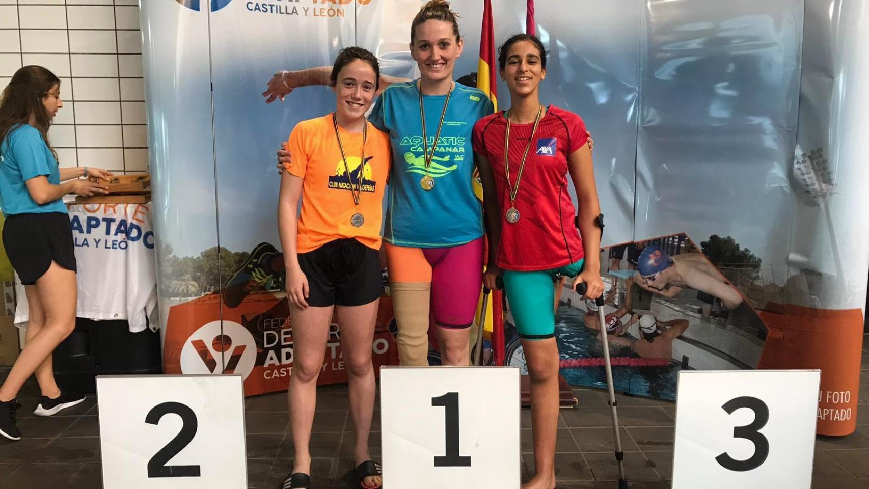 Laura Mengó Hernández, en el centro, tras ganar una competición de natación adaptada. CD Aquàtic Capmanar