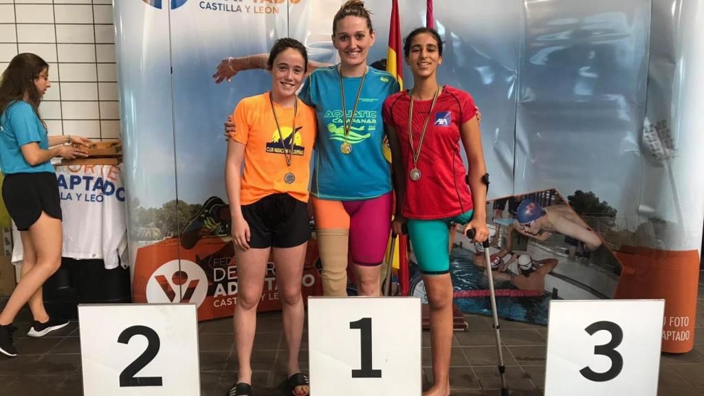 Laura Mengó Hernández, en el centro, tras ganar una competición de natación adaptada. CD Aquàtic Capmanar