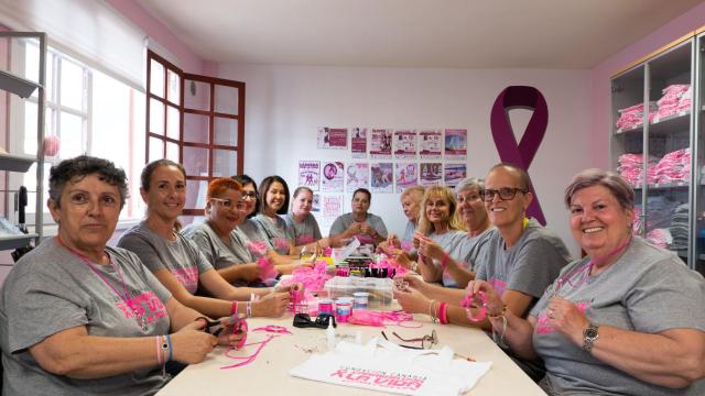 Voluntarias de Carrera por la Vida preparando pulseras de concienciación.