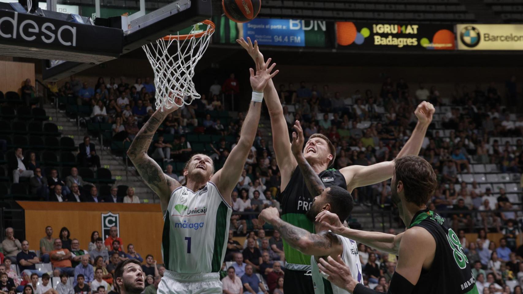 El pivot estadounidense de Unicaja, Osetkowski (i), pelea un rebote en el jugador sueco del Joventut, Simon Birgander.