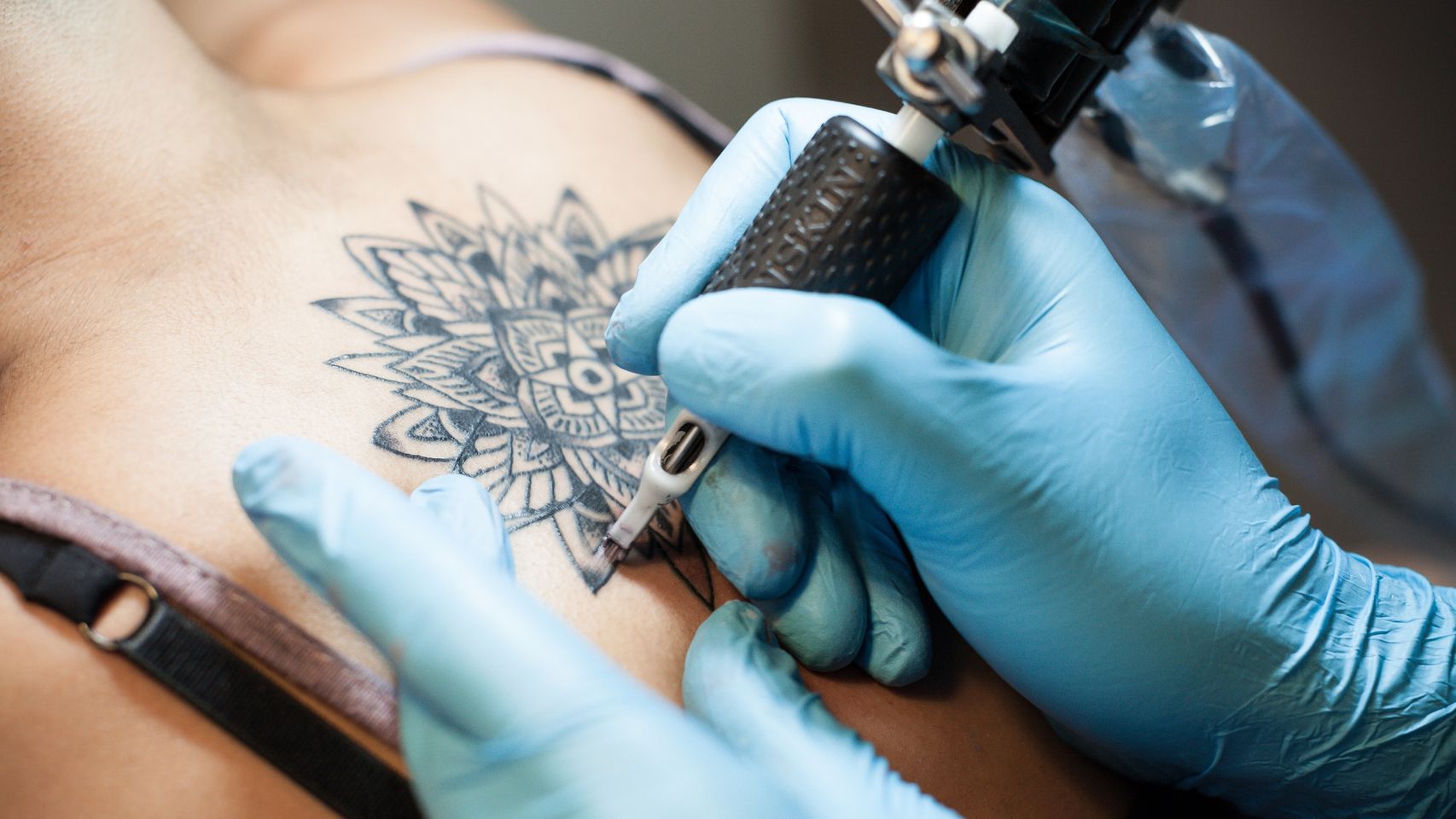 Imagen de archivo de persona tatuándose la espalda