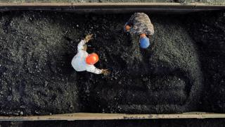 Dos mineros separan piedras del carbón antes de transportarlo a una mina, en México.