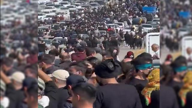 Iraníes caminan por la carretera hacia el cementerio donde se encuentran los restos de Mahsa Amini.