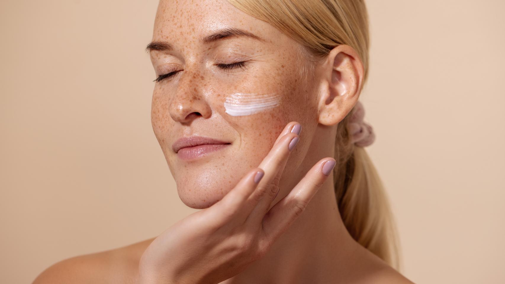 Una mujer echándose crema.