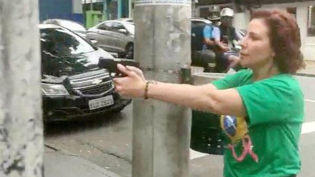 La diputada brasileña Carla Zambelli apunta con una pistola, en las calles de Sao Paulo.