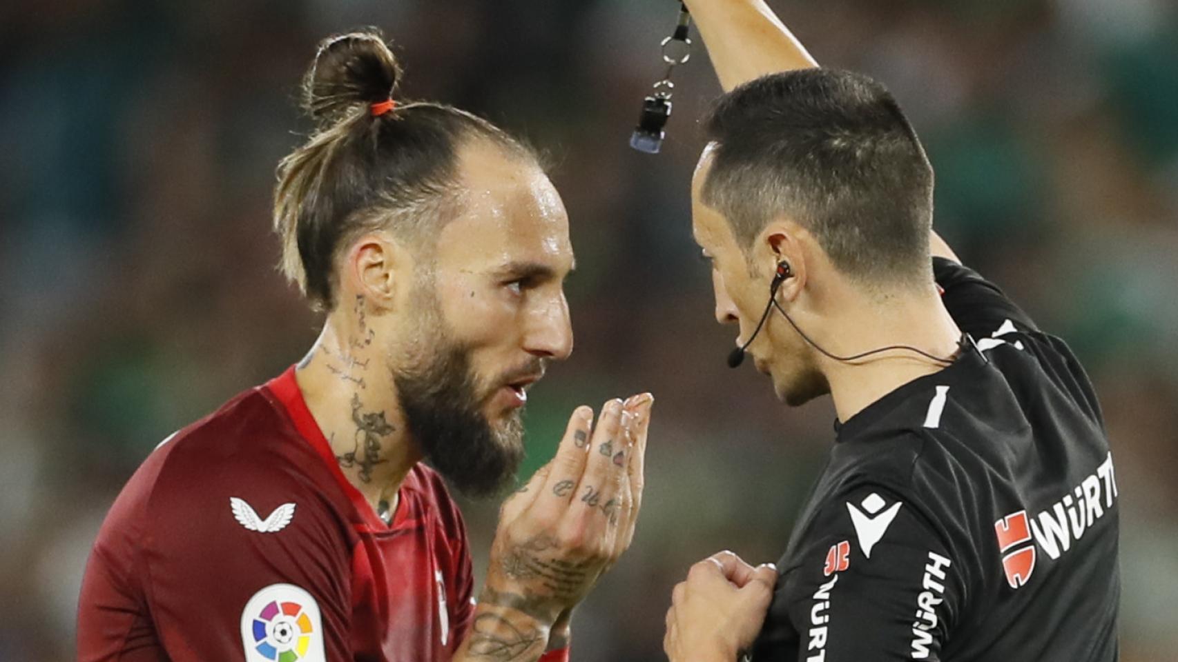 Gudelj, del Sevilla, ante el árbitro pidiéndole que se vaya.