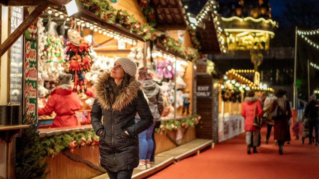 Una mujer pasea por un mercadillo navideño.