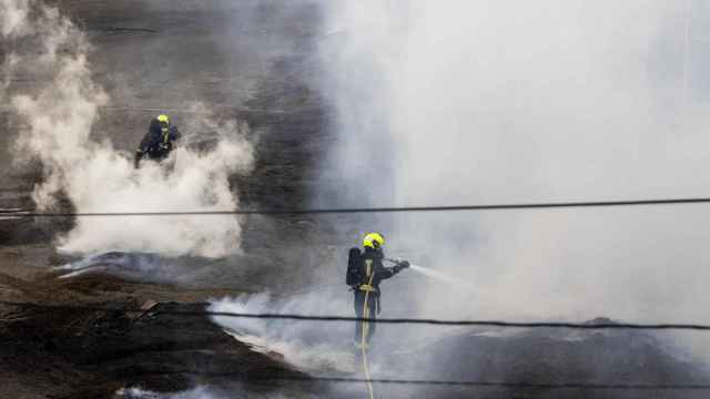 Dos bomberos trabajan en la extinción del fuego de la antigua fábrica de Pontesa dos días después de iniciarse el incendio.