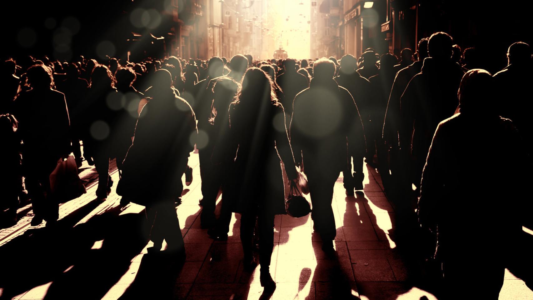 Aglomeración de gente en una calle transitada