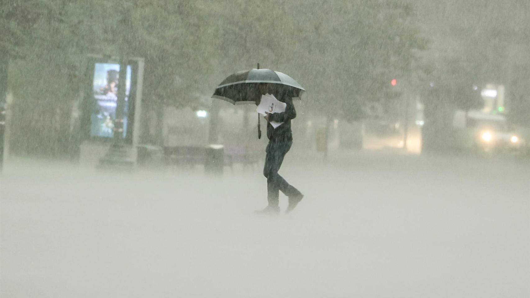 Un hombre camina bajo la intensa lluvia este viernes en Valencia.