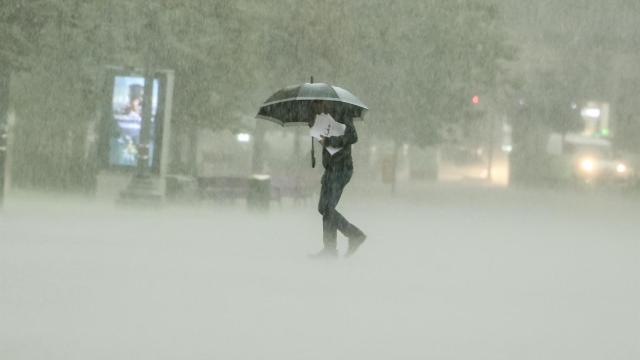 Un hombre camina bajo la intensa lluvia este viernes en Valencia.