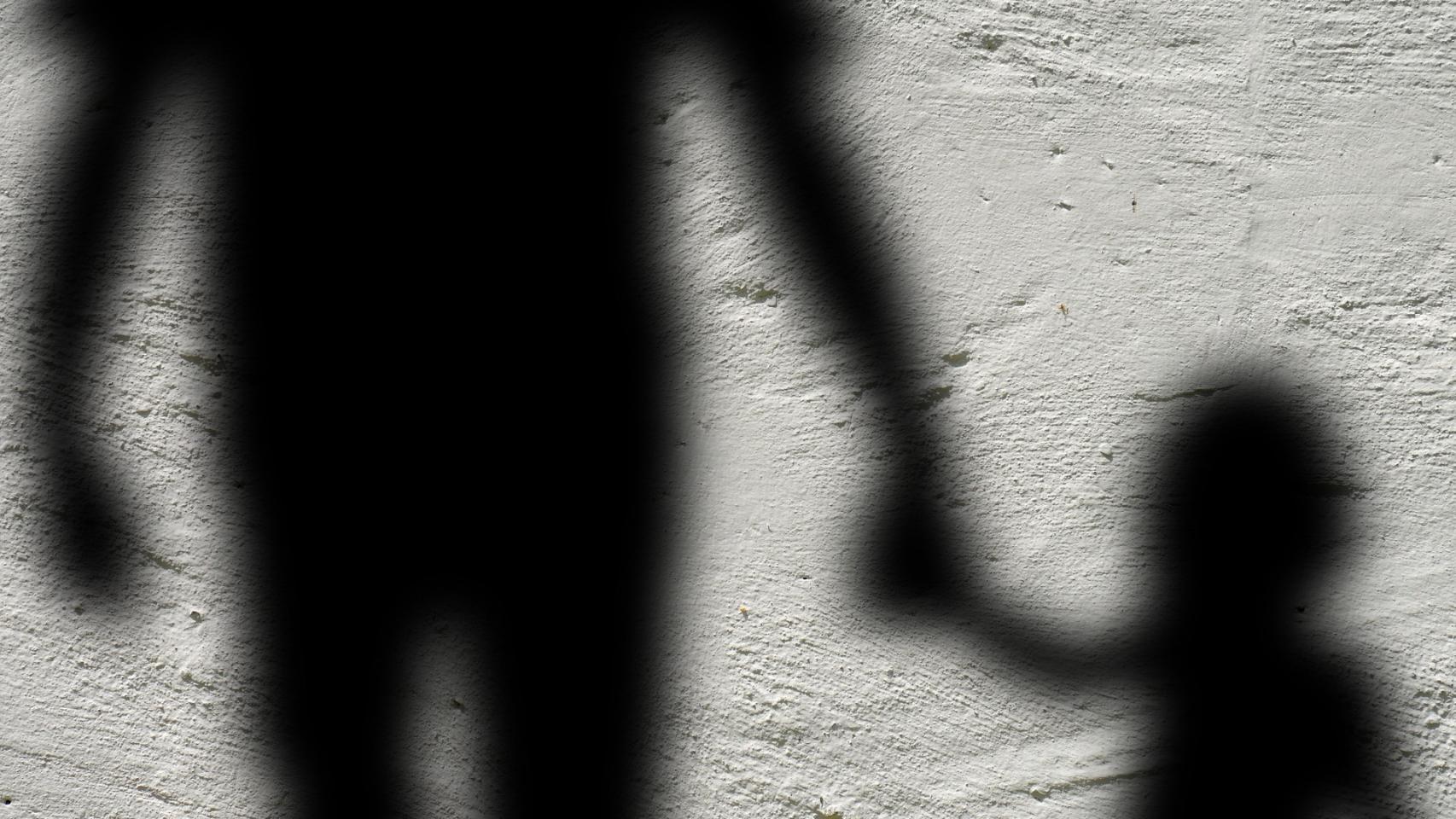 Imagen de archivo de las sombras de un adulto y una niña.