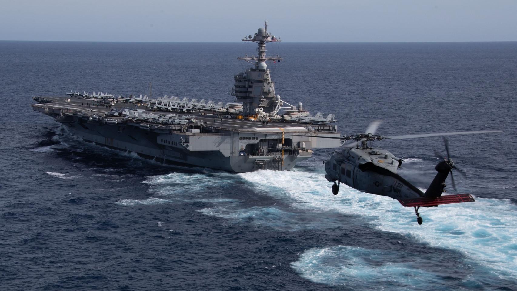 El USS Gerald R. Ford y un helicóptero MH-60S Seahawk