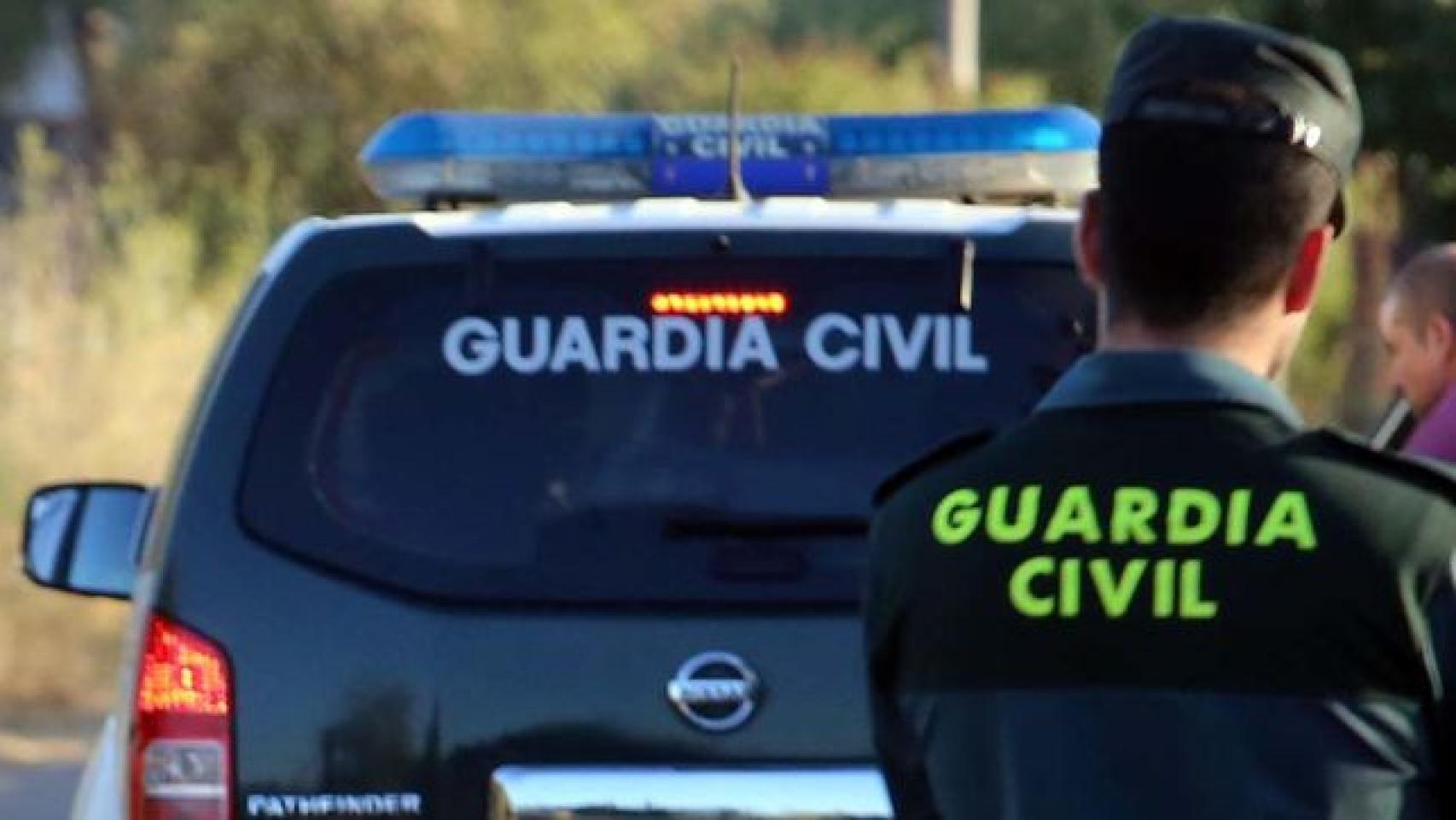 Un coche y un agente de la Guardia Civil, en imagen de archivo.