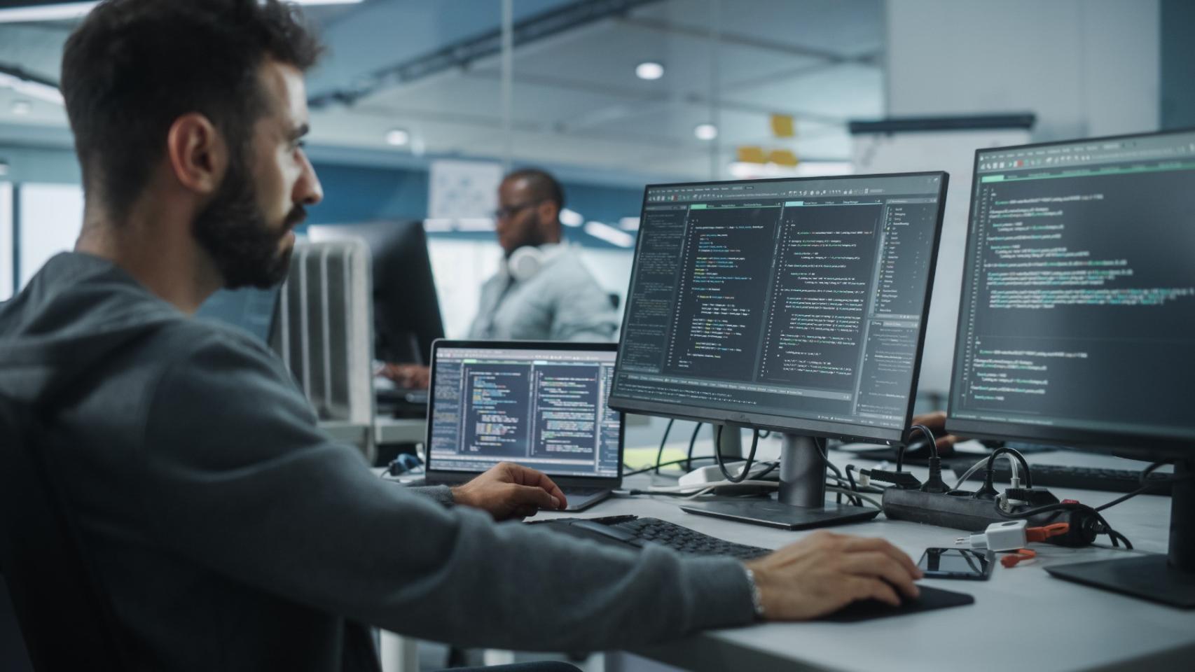 Un programador de TI trabaja con su ordenador en una oficina.