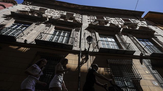 Varios turistas pasan por un bloque de apartamentos en la ciudad de Valencia, en imagen de archivo.