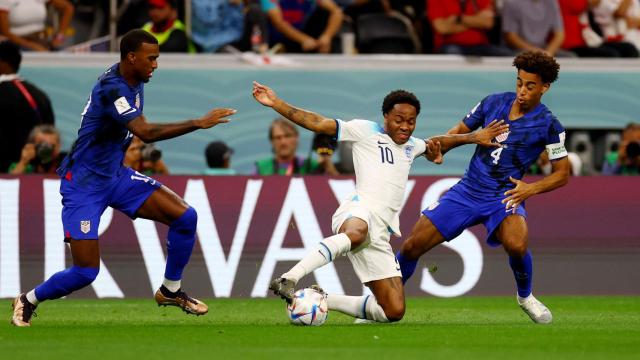 Sterling se lleva el balón ante dos rivales de Estados Unidos.