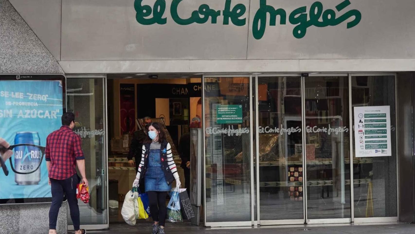 Clientes entrando y saliendo de un centro comercial de El Corte Inglés.