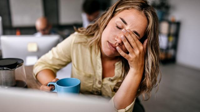 Una mujer cansada con una taza de café