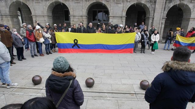 Varias personas portan una bandera de Colombia con un lazo negro durante una concentración en repulsa por el asesinato de Cristina Cabo en Lugo.