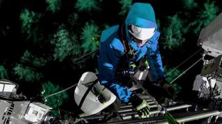 Un operario realizando trabajos en una torre de telecomunicaciones.