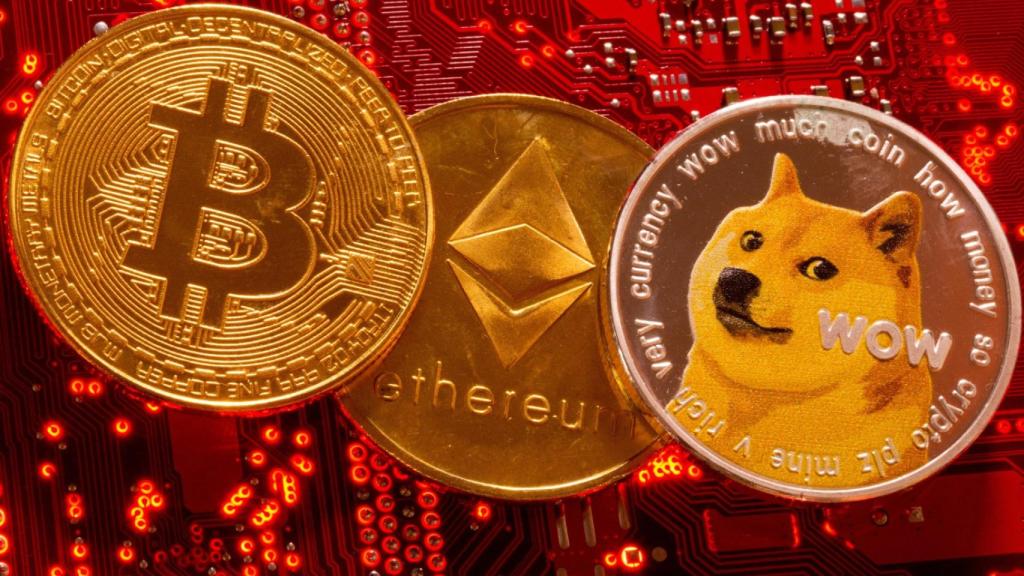 Representación de las criptomonedas Bitcoin, Ethereum y DogeCoin sobra la placa base de un ordenador.