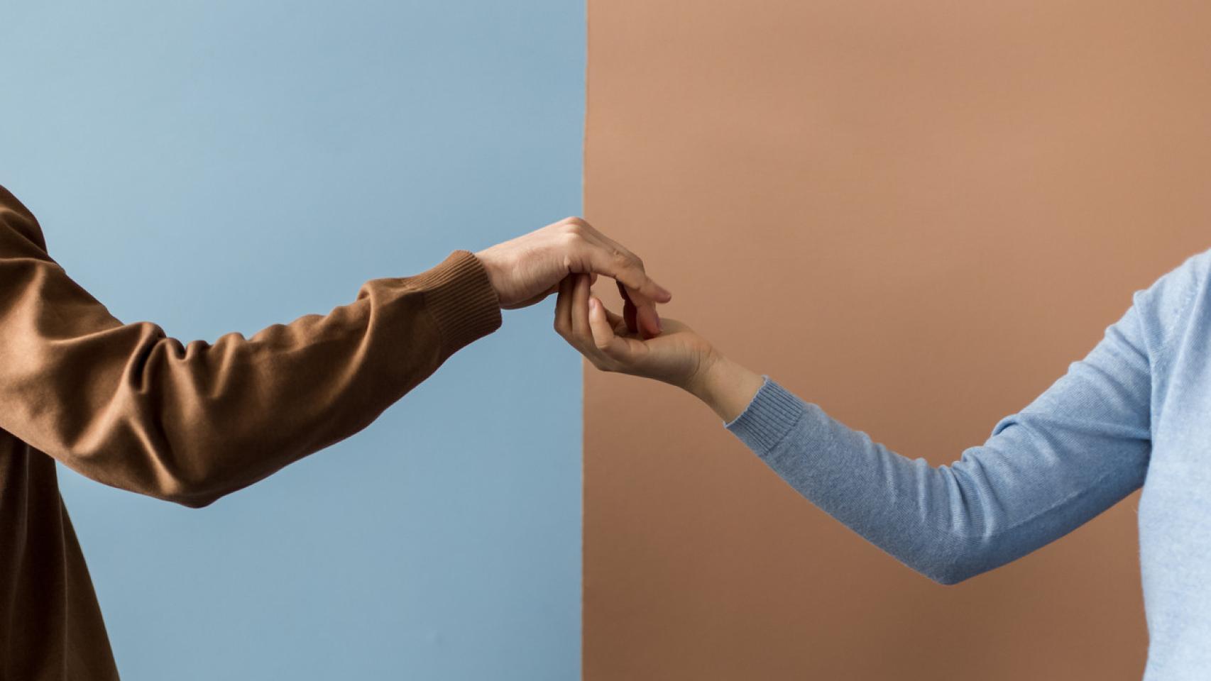 Una pareja, dándose la mano.