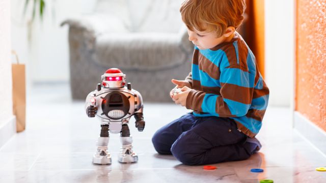 Un niño jugando con un robot.