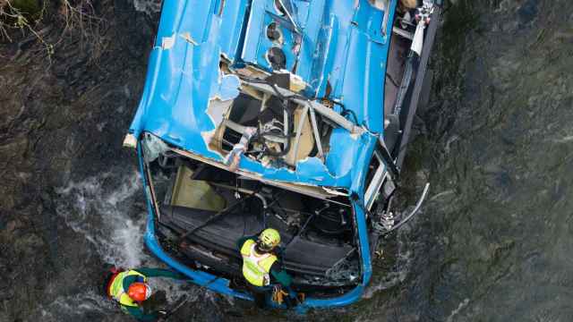 Efectivos de la Guardia Civil trabajan en las labores de desbrozamiento y preparación del autobús accidentado para sacarlo del Lérez en Cerdedo-Cotobade (Pontevedra).