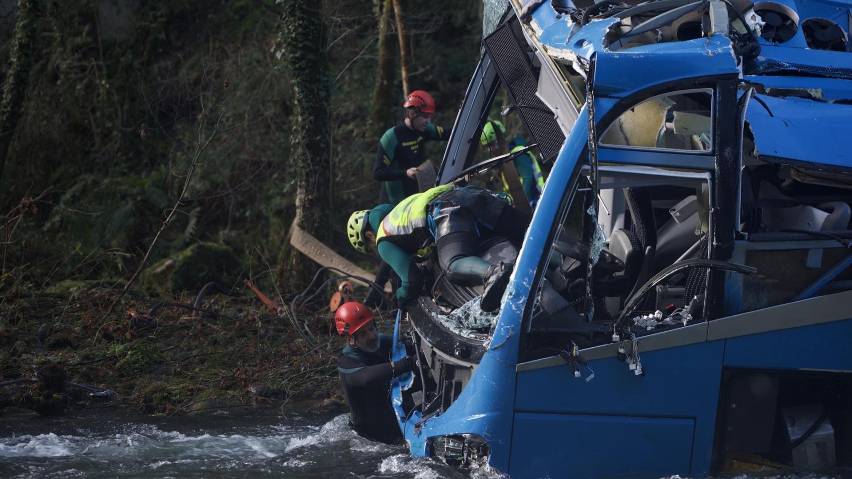 Varios efectivos del Grupo Especial de Actividades Subacuáticas de la Guardia Civil (GEAS) participan en la labor de izado del autobús accidentado.