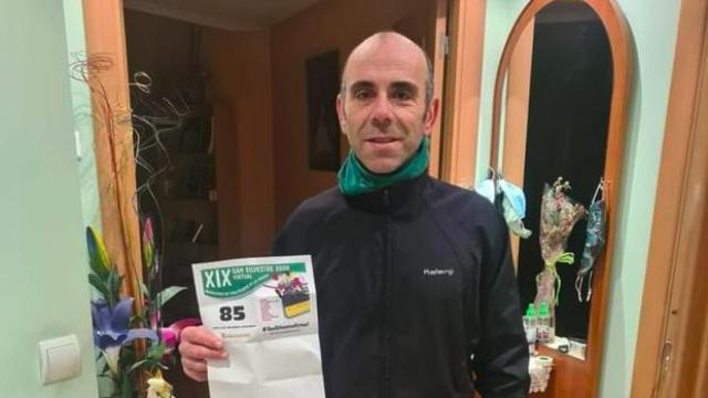 José Luis González sostiene un panfleto de la San Silvestre de la Virgen del Carmen de 2020