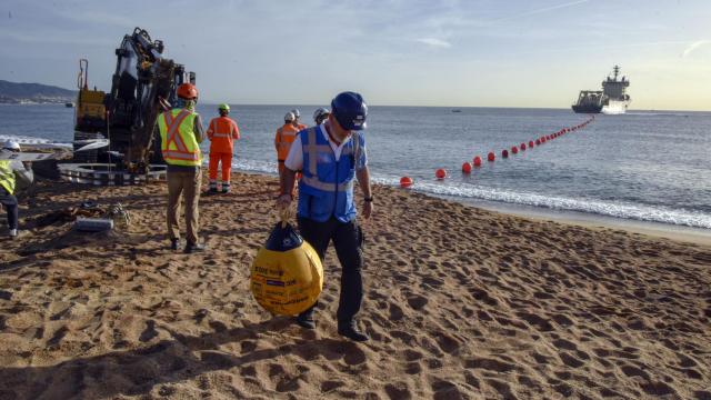 Un trabajador con la punta del cable submarino 2Africa a su llegada a la Barcelona Cable Landing Station (CLS) de Sant Adrià de Besòs (Barcelona) en  octubre de 2022.