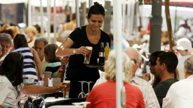 Una camarera sirve una mesa.