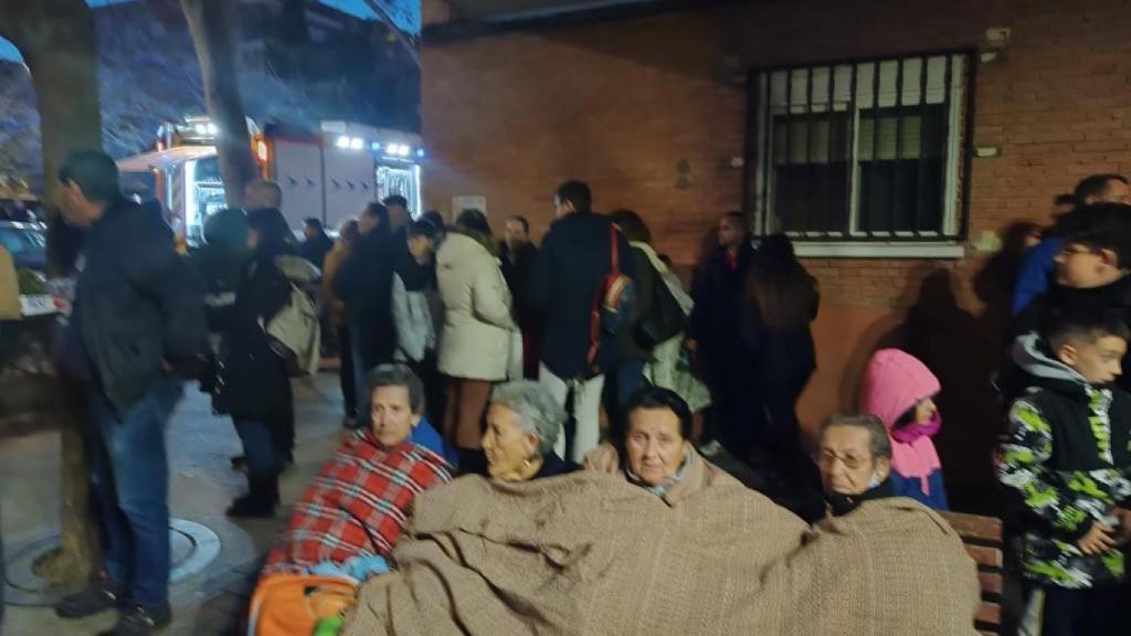 Cuatro ancianas, tapadas con mantas, durante el desalojo de sus casas este martes.