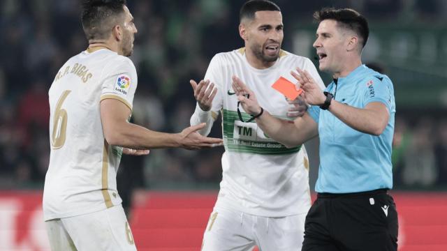 El colegiado Ortiz Arias (d) muestra tarjeta roja al defensa del Elche Pedro Biga (i) durante el partido de LaLiga Santander entre el Elche CF y el RC Celta de Vigo.