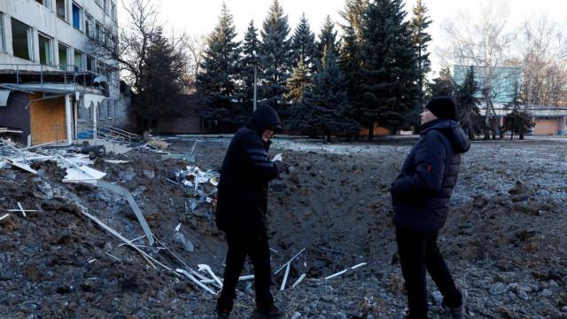 Cráter en el suelo frente a un edificio ucraniano