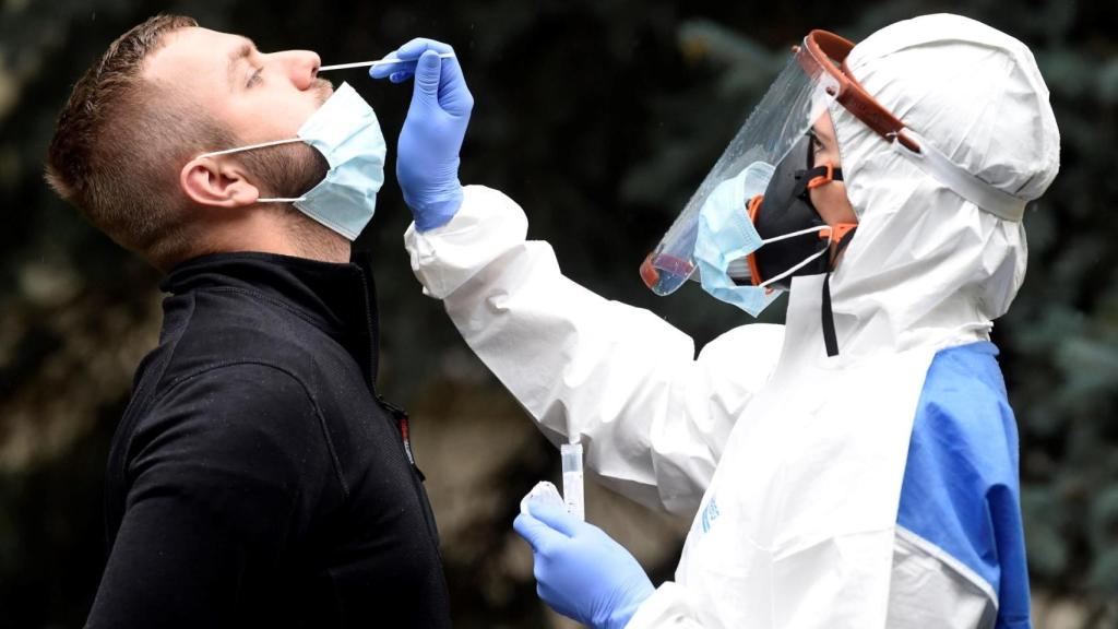 Un sanitario toma una muestra para una PCR.