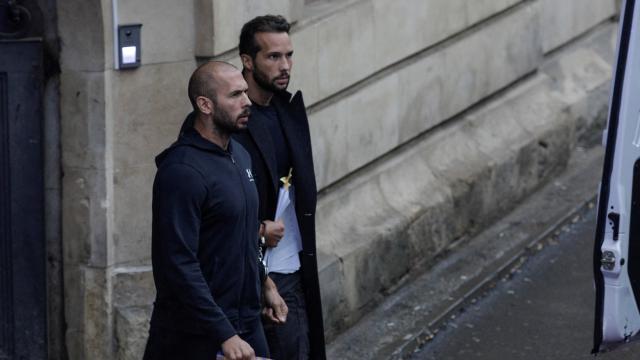 Andrew Tate sale del Tribunal de Apelación de Bucarest esposado junto a su hermano y con un Corán en las manos.